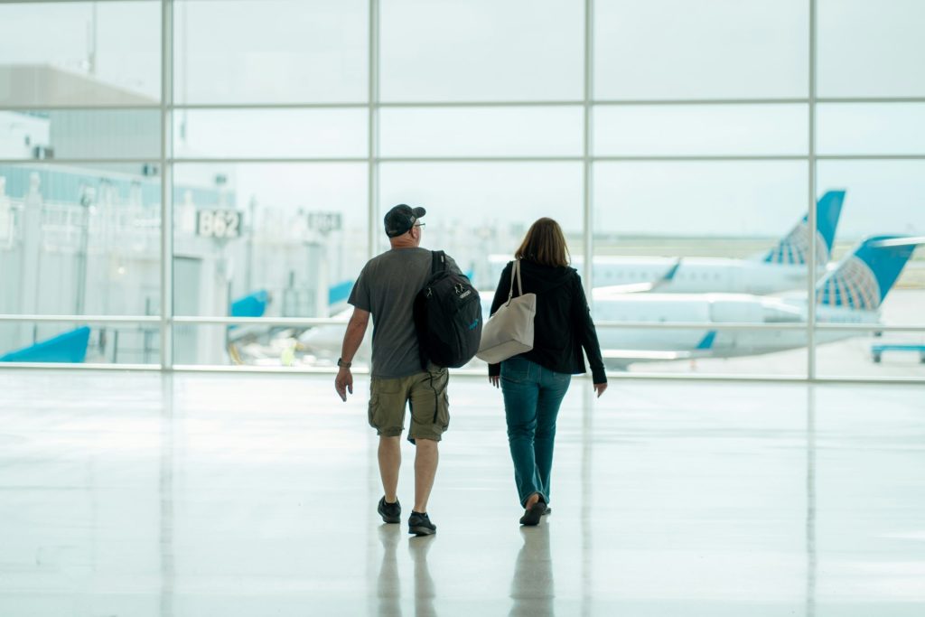 un homme et une femme traversant un aéroport